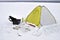 Winter fishing place with a yellow tent and the necessary attributes for fishing