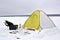 Winter fishing place with a yellow tent and the necessary attributes for fishing