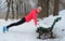 Winter fitness and running in park: happy woman runner warming up and exercising before jogging in snow