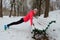 Winter fitness and running in park: happy woman runner warming up and exercising before jogging in snow