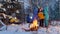 Winter forest. Camping. Family standing in the woods by the fire. Making a selfie