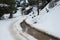 Winter forest landscape with frozen impassable road