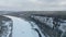 Winter forest landscape and pine tree forest growing on cliff over frozen river in snow. Clip. Breathtaking aerial view