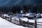 Winter forest scene. Small cottages along a tree line in a sunny winter day. Snowy fairytale in Bulgaria.