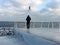 Winter, frost, ice-covered pier, a seagull over a man