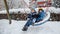 Winter fun and laughter as two brothers swing on a snow-covered playground. Outdoor activity and family enjoyment