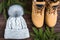 Winter gray knitted hat with boom and yellow boots on wooden background