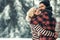 Winter happy couple in love embrace in snowy cold forest, winter holiday love and relations.