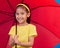 Winter, happy and portrait of a child with an umbrella, open and red while isolated in a studio. Smile, safety and a