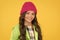 Winter hat styles. Kid girl wear knitted hat. Winter accessory concept. Girl long hair yellow background. Cold season