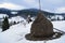 Winter haystack on a background of green firs.