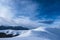 Winter Hiking Path and hiker in the background . Hiking in the winter time on a lovely sunny day. White peaks