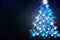 Winter holiday background with blue Christmas tree shape from lights