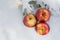 Winter holiday concept: ripe organic jonagold apple in snow and frozen snow covered pine tree twig in forest