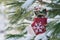 Winter holiday decoration concept: snowflake crochet Christmas stocking and frozen snow covered pine tree twigs in forest