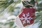 Winter holiday decoration concept: snowflake crochet Christmas stocking and frozen snow covered pine tree twigs in forest