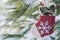 Winter holiday decoration concept: snowflake crochet Christmas stocking and frozen snow covered pine tree twigs in forest