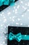 Winter holiday gifts with emerald silk bow and glowing snow on frozen marble background, Christmas presents surprise