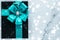 Winter holiday gifts with emerald silk bow and glowing snow on frozen marble background, Christmas presents surprise