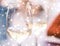 Winter holiday glasses of white wine and glowing snow on background, Christmas time romance