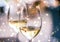 Winter holiday glasses of white wine and glowing snow on background, Christmas time romance