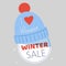 Winter holiday sale vector illustration. Knitted cap or hat with love heart icon and winter sale inscription. Warm