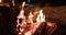 Winter holiday ski resort people roasting marshmallows in BBQ firepit afterski fun leisure activity with friends. Couple