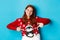 Winter holidays and Christmas Eve concept. Pretty redhead girl pointing fingers at cute xmas sweater with penguin