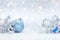 Winter holidays composition on white snow with christmas tree branches, decorative blue ball, silver glass star and drums toy