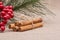 Winter Holidays decoration red poinsettia, pine and berry bush with cinnamon sticks tied with jute rope on burlap