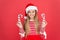 Winter holidays. Playful mood. Christmas celebration ideas. Shine and glitter. Child Santa Claus costume hat. Happy