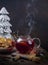 Winter hot tea with dried lemons, berries and spices in glass teapot with steam