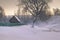 Winter house and tree on frozen river on morning in Russia