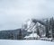 Winter houses on winter mountain landscape with white snowy spruces. Amazing view on snowcovered forested mountain slope.