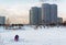 Winter ice fishing, lake, frosty day. Fisherman engaged in ice fishing in the pond of the city Park