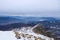 Winter landscape, alpine valley and snowcapped mountain range, clouds overcast dark.