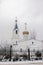 Winter landscape, a beautiful white temple with a bell tower and a golden dome and a golden cross