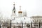 Winter landscape, a beautiful white temple with a bell tower and a golden dome and a golden cross