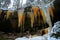 Winter landscape with big icicle in the forest with snow. Ceske Svycarsko, Czech Republic. Melted icicles in the spring time on th