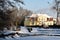 Winter landscape in the city park. Rumia, Poland. Ducks in frozen and snowy park pond.