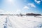Winter landscape. Countryside. Snowy road. Sunny day. Blue sky. White clouds