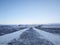 Winter landscape, deserted walking road through a field to the beach in iceland. Huge open space, the road is marked with yellow