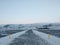 Winter landscape, deserted walking road through a field to the beach in iceland. Huge open space, the road is marked with yellow