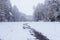 Winter landscape with empty snowy road, frozen steam and trees in snow