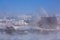 Winter landscape in the fog with a small village in Russia. Small snow-covered houses, smoke from chimneys. Trees covered with