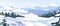 Winter landscape with hills in snow, fir trees and sky. Panoramic snowy nature scene. Scenery with mountains in cold