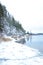 Winter landscape with a lake and a rocky shore and snow-covered pines. Swedish, Finnish, Karelian landscape