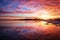 Winter landscape with lake and sunset fiery sky.