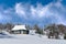 Winter landscape. Lonely cottage on the background of the winter forest