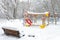 Winter landscape in Moscow, Russia. Scenery of empty snowy bench and playground. Scenic view of urban park under snow